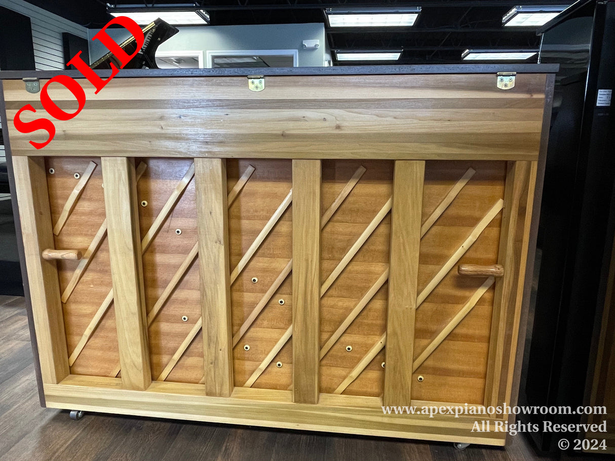 A wooden piano harp with exposed strings and soundboard, ready for installation, displayed in a showroom setting.