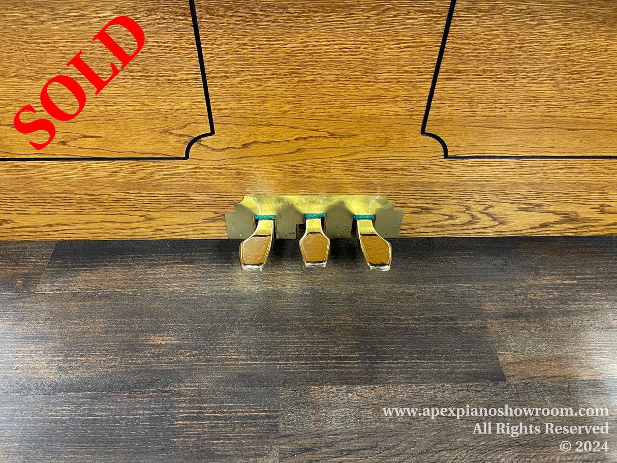 Brass piano caster cups placed underneath the wheels of an upright piano to protect the wooden floor.