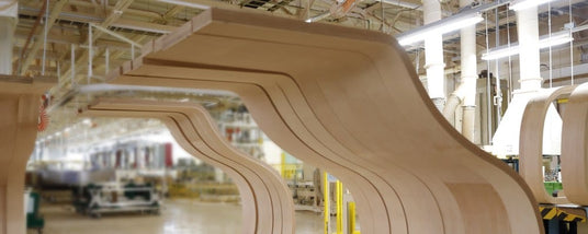 Grand piano wooden frames lined up in a piano manufacturing plant.