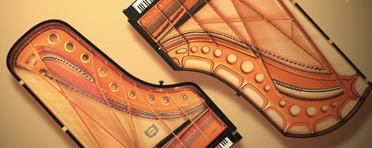 Grand piano interior mechanisms with strings, soundboard, and frame, exhibited without the case for educational or display purposes.