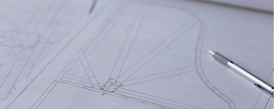 Blueprint of a grand piano design with a focus on the intricate layout of the frame and strings, accompanied by a mechanical pencil on the drafting paper.