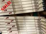 Close-up view of a set of piano hammers with numbered parts, indicating specific notes within a piano mechanism. Each hammer is equipped with a red felt pad on the striking surface, aligned neatly in a row.