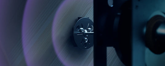 Close-up of a modern piano's tuning pins and strings with a blurred background, highlighting the precision engineering involved in piano manufacturing.