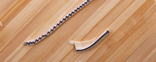 Piano keys partially deconstructed, with visible hammers and dampers on a wooden surface, highlighting the interior mechanism of a piano.